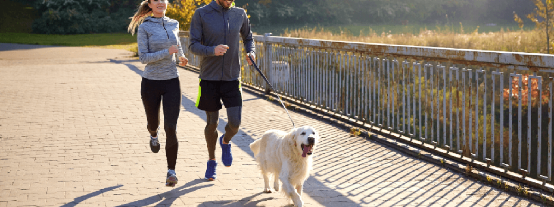 Happy couple with dog running outdoors